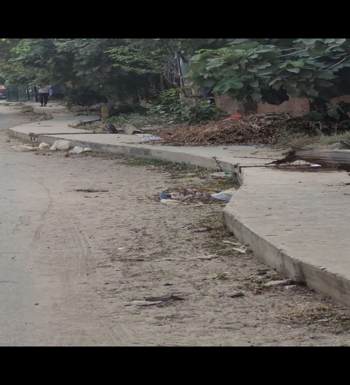 Winding storm water drain made on one side of the road and the unusable foot path